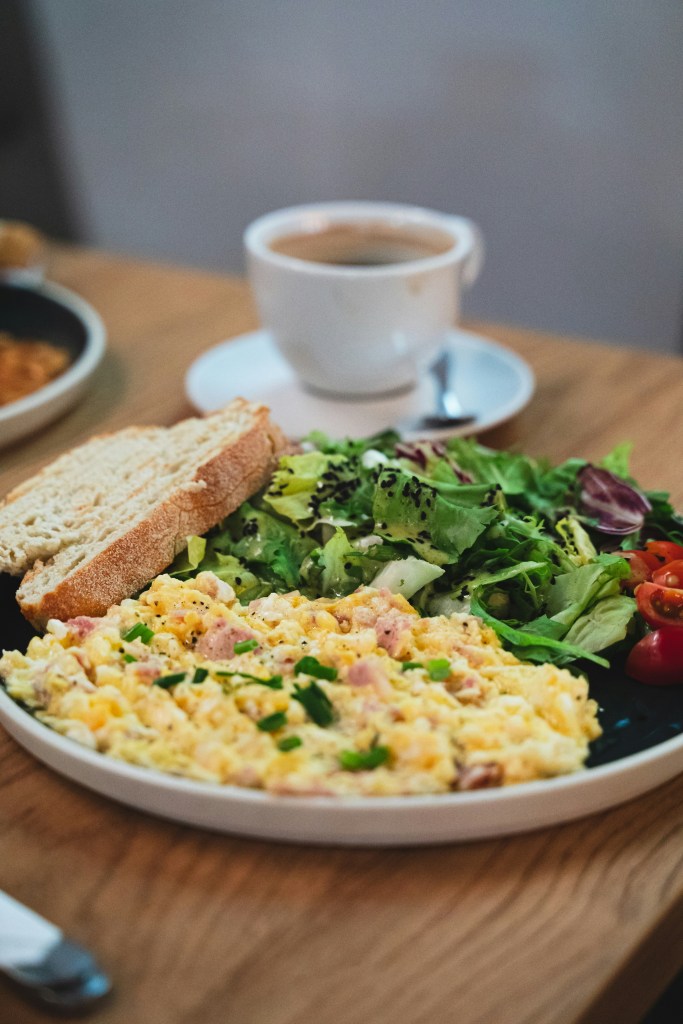 High-protein veggie egg scramble with spinach, red pepper and feta in a pan